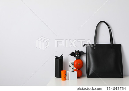 Black bag with Halloween decorations on a white background 114843764