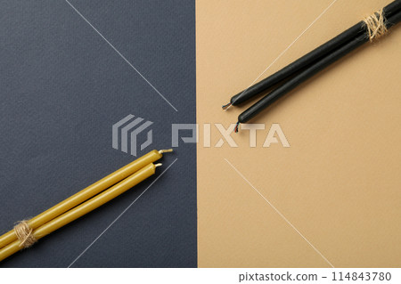 Light and dark magic candles twisted into a pile. 114843780