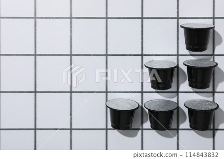Black coffee capsules on light background, space for text 114843832