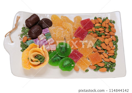 Marmalade, candied fruit, mango, kiwi, nuts, seeds, chocolate candies and Turkish delight in a plate. Variety of sweet desserts in plate. 114844142