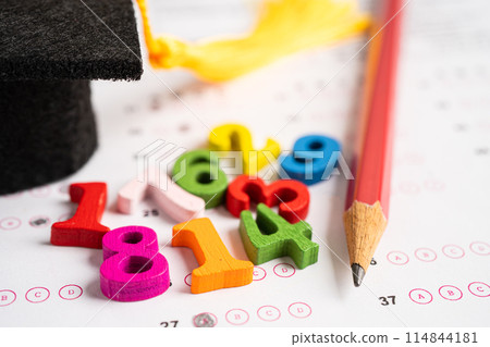 Graduation gap hat and pencil on answer sheet paper, Education study testing learning teach concept. Graduation gap hat and pencil on answer sheet paper, Education study testing learning teach concept. 114844181