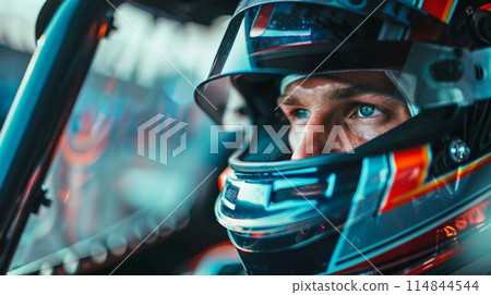 Close-up portrait of race car driver, pilot in helmet in moments before race, his eyes fixed with steely determination. Close-up portrait of race car driver, pilot in helmet in moments before race, his eyes fixed with steely determination. 114844544