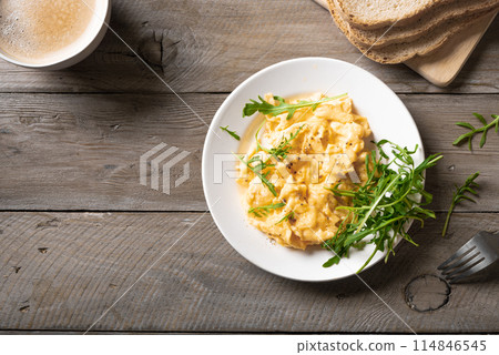 Scrambled eggs with arugula salad for breakfast. Scrambled eggs with arugula salad for breakfast. 114846545