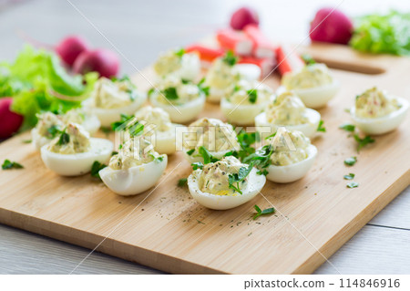stuffed eggs, deviled eggs on a wooden table 114846916