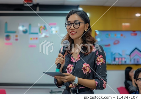 A beautiful woman architect presents a project with a city view in the background at the office. A beautiful woman architect presents a project with a city view in the background at the office. 114847107