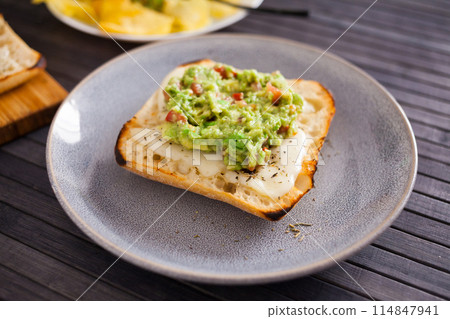 Morning toast with melted cheese and guacamol Morning toast with melted cheese and guacamol 114847941