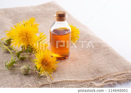 Dandelion flowers and dandelion flowers tincture on cloth. Flat lay 114848001