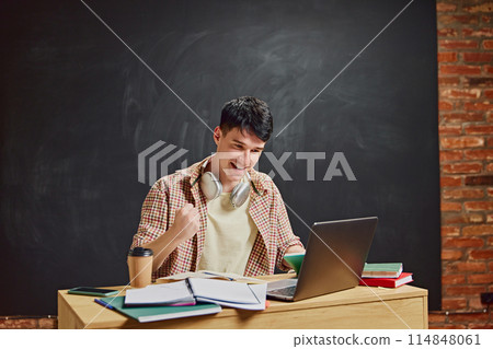 Happy smiling man, student celebrating successful study session, solving challenging task. Chalkboard background 114848061
