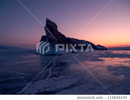 Ogoy island on winter Baikal lake. Winter scenery of Dragon Tail Rock on Ogoy island during sunrise at Lake Baikal. 114848249