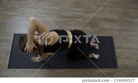 A woman from a knee elbow position making the bends of the body. Media. Concept of sport and body care. 114848527