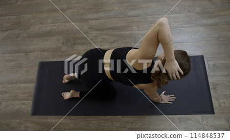 A woman from a knee elbow position making the bends of the body. Media. Concept of sport and body care. A woman from a knee elbow position making the bends of the body. Media. Concept of sport and body care. 114848537