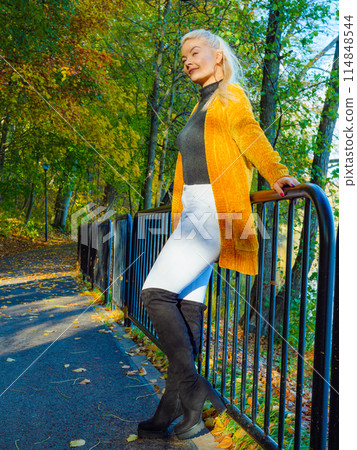 Woman walking in autumn park 114848544