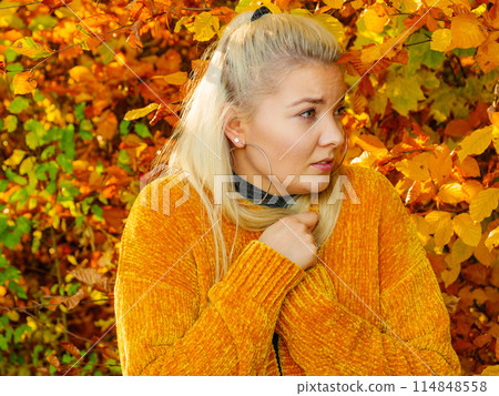 Woman in autumn park warming herself 114848558
