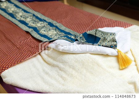 Bed in massage room with white towel and red blanket. Place for relaxation. 114848673