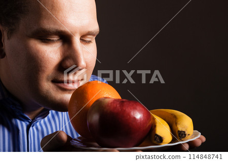 Diet nutrition. Happy young man smelling fruits. Diet nutrition. Happy young man smelling fruits. 114848741