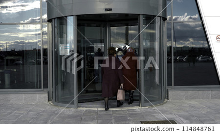 A revolving door in modern building, shopping center. Media. Glass rotating door, turntable entrance to the business center, time lapse. A revolving door in modern building, shopping center. Media. Glass rotating door, turntable entrance to the business center, time lapse. 114848761