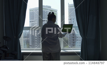Young woman working from home, concept of freelance or remote work. Media. Woman with a laptop with chroma key green screen. Young woman working from home, concept of freelance or remote work. Media. Woman with a laptop with chroma key green screen. 114848797