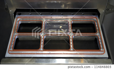 Production of plastic packages, industrial background. Media. Close up of conveyor belt with plastic small boxes. Production of plastic packages, industrial background. Media. Close up of conveyor belt with plastic small boxes. 114848803