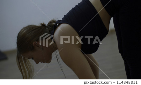 Person exercising at home. Media. Woman stretching body, doing yoga at home alone. Person exercising at home. Media. Woman stretching body, doing yoga at home alone. 114848811