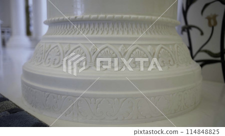 Close up of white beautiful pillar with carved pattern. Scene. Interior details of a white mosque. Close up of white beautiful pillar with carved pattern. Scene. Interior details of a white mosque. 114848825