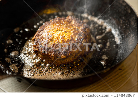 Hamburger cooked in a frying pan 114848867