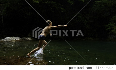 Boy child jumping in cold mountain river on a summer day. Creative. Hiking in summer jungles. 114848908