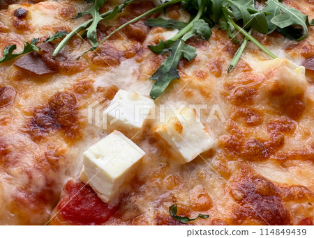A pizza with cheese and spinach on top. The pizza looks delicious and appetizing A pizza with cheese and spinach on top. The pizza looks delicious and appetizing 114849439