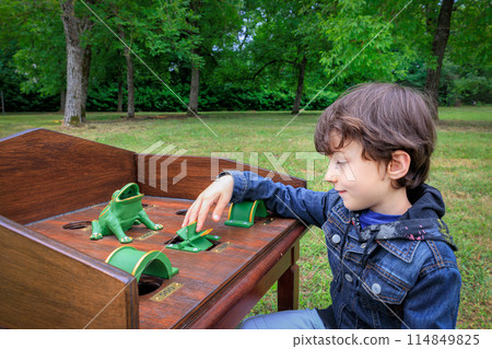Child playing gioco della rana table game outdoors 114849825