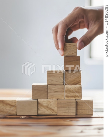 Strategic Planning: Man Organizing Wooden Cubes for Business 114850285