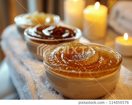 Sugar paste or wax honey in a transparent jar and white orchid on a white background. Sugaring. Sugar paste or wax honey in a transparent jar and white orchid on a white background. Sugaring. 114850576