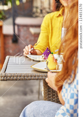 Women enjoying colorful fruit shaped desserts at outdoor cafe Women enjoying colorful fruit shaped desserts at outdoor cafe 114851570