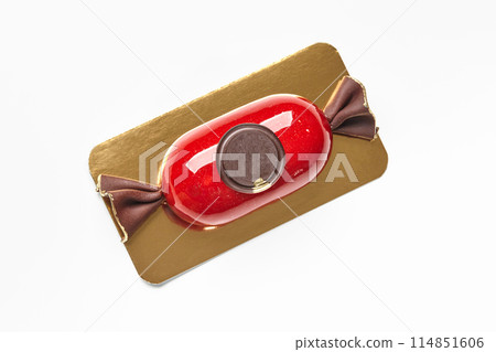 Candy-shaped mousse dessert with red glaze and chocolate seal Candy-shaped mousse dessert with red glaze and chocolate seal 114851606