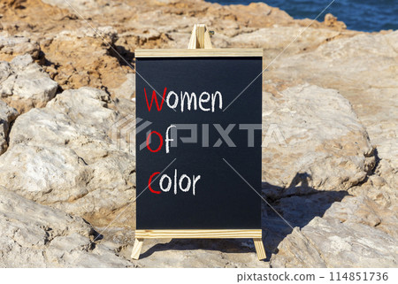 WOC women of color symbol. Concept words WOC women of color on beautiful yellow blackboard. Beautiful stone blue sky sea background. Business WOC women of color social issues concept. Copy space. WOC women of color symbol. Concept words WOC women of color on beautiful yellow blackboard. Beautiful stone blue sky sea background. Business WOC women of color social issues concept. Copy space. 114851736