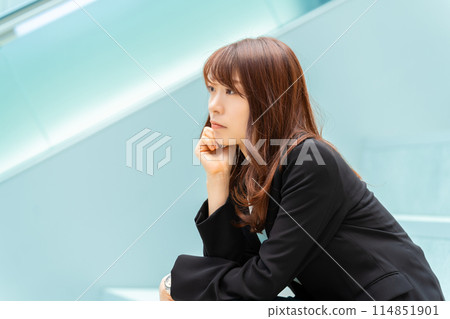 A businesswoman sitting and thinking 114851901