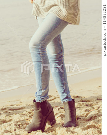 Woman wearing autum shoes on beach 114852251