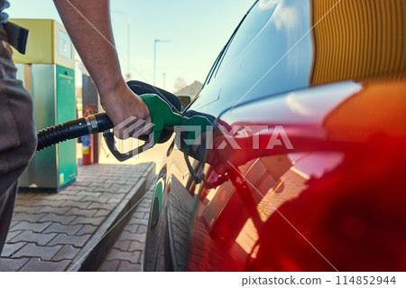 Fuel station nozzle filling car tank 114852944