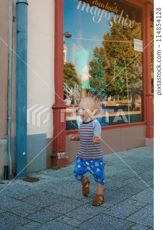 Child run and play on street on Szombathely in Hungary. Traveling in Szombathely city, Hungary. 114854128