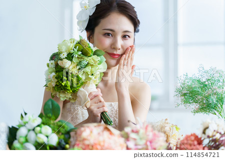 Bride putting on wedding ring and engagement ring 114854721