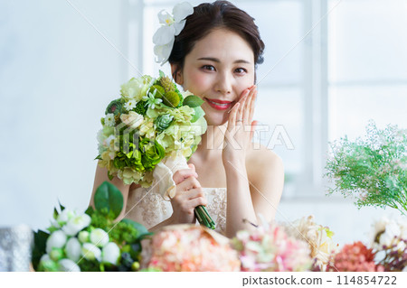 Bride putting on wedding ring and engagement ring 114854722