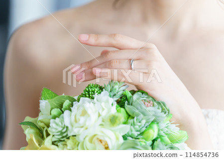 Bride putting on wedding ring and engagement ring Bride putting on wedding ring and engagement ring 114854736