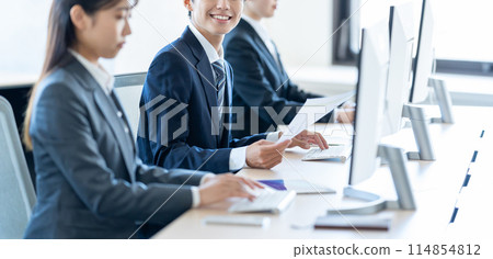 Male and female new employees working on computers 114854812