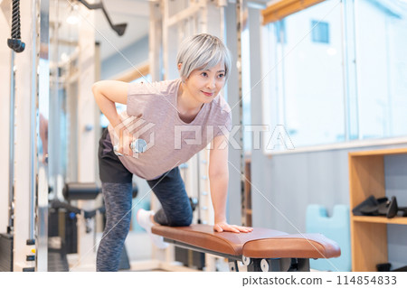 Middle-aged woman doing muscle training at the gym 114854833