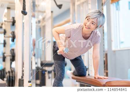 Middle-aged woman doing muscle training at the gym 114854841