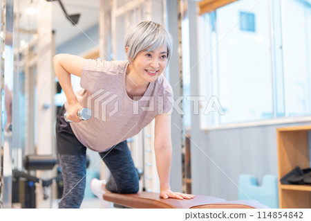 中年婦女在健身房進行肌肉訓練 114854842