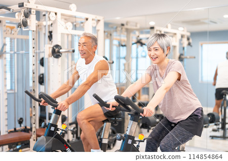 Senior couple exercising at a fitness gym 114854864