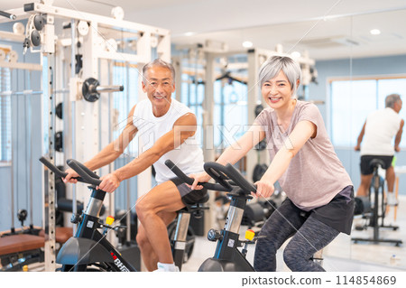 Senior couple exercising at a fitness gym Senior couple exercising at a fitness gym 114854869