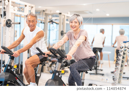Senior couple doing aerobic exercise at the gym Senior couple doing aerobic exercise at the gym 114854874