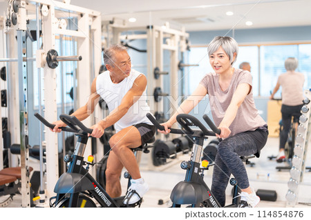 Senior couple doing aerobic exercise at the gym Senior couple doing aerobic exercise at the gym 114854876