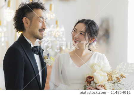 Bride and groom in dress and tuxedo Bride and groom in dress and tuxedo 114854911