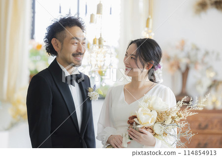 Bride and groom in dress and tuxedo Bride and groom in dress and tuxedo 114854913